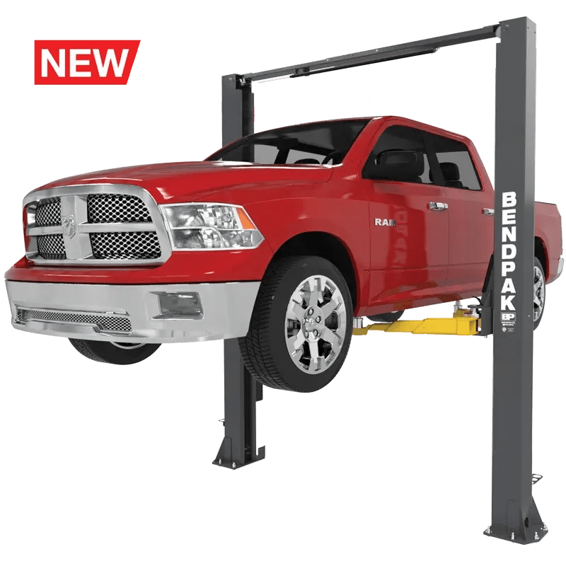 BendPak 10APX two-post lift in hero view raising a red pickup truck, featuring clearfloor design, overhead beam, and yellow triple-telescoping lift arms.