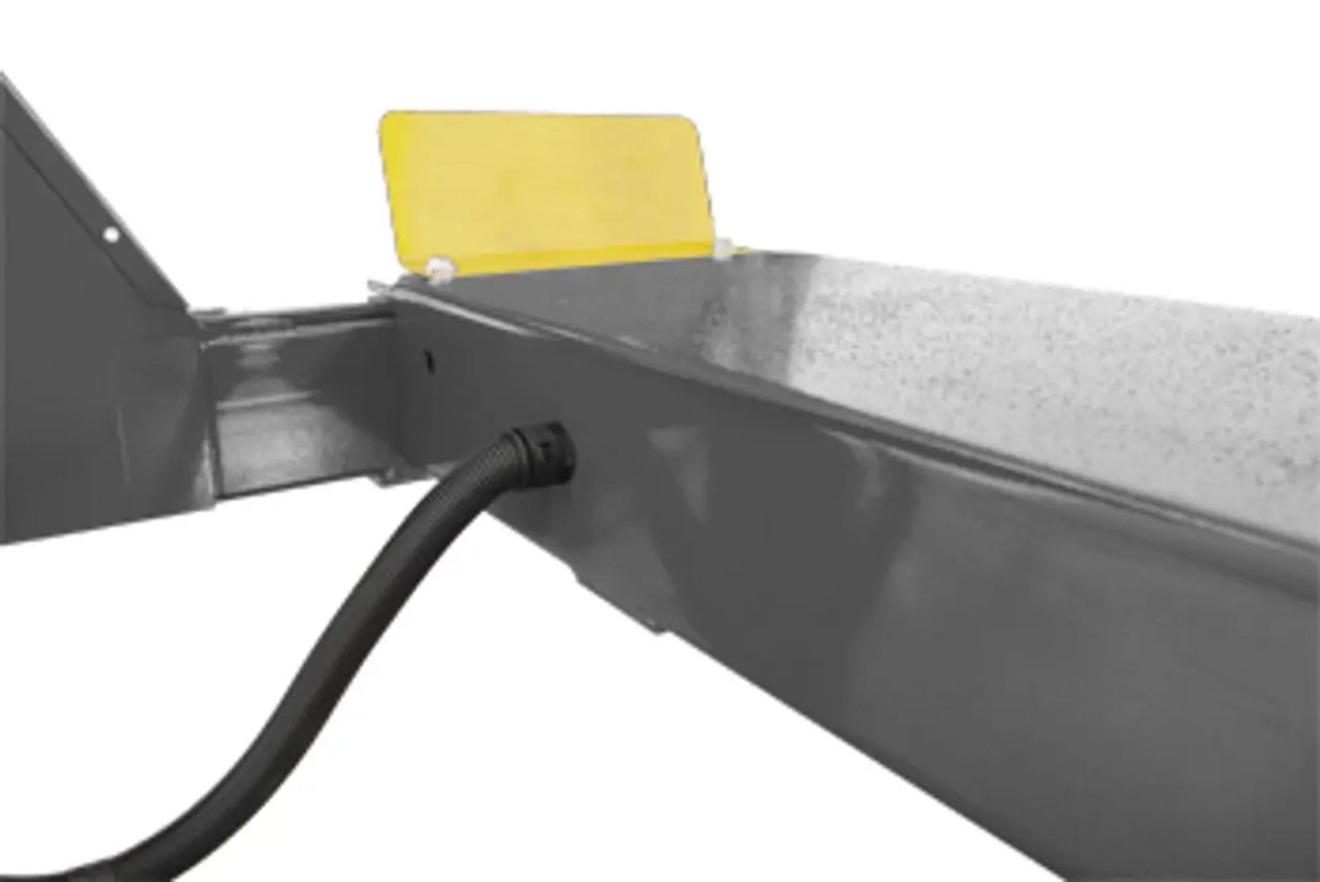 BendPak HDS-14X four-post lift ramp end with hydraulic hose connection and yellow wheel stop, showing cable routing through frame.