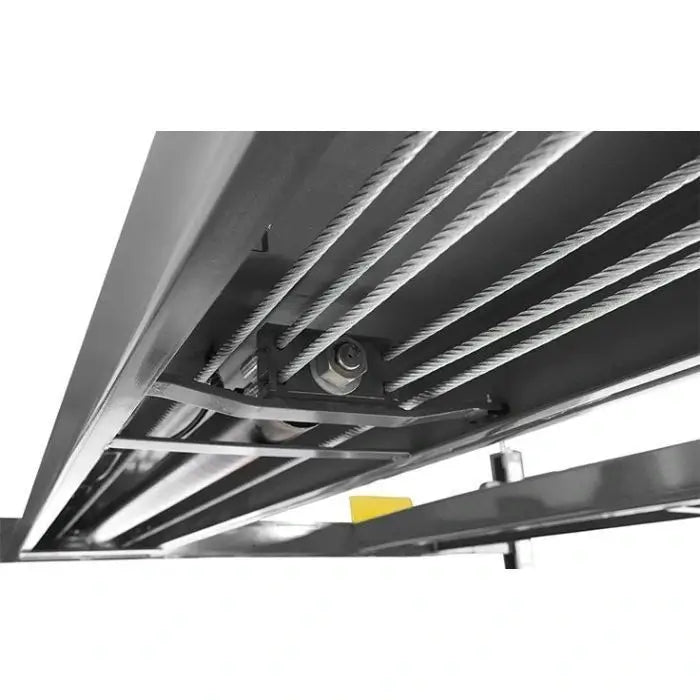 BendPak HDSO14P four-post lift underside view showing steel cable routing and pulleys for synchronized platform lifting operation