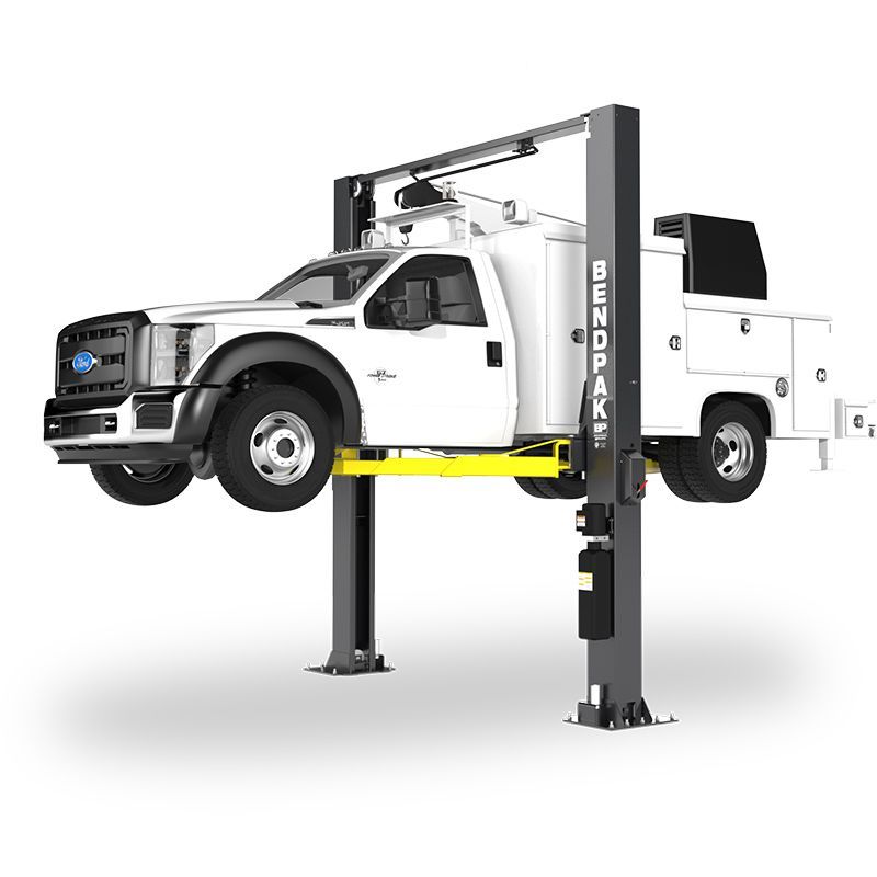 BendPak XPR-12CL-192-LTA two-post lift raising a white Ford service truck; hero view highlighting extended-height columns and long-reach telescoping arms