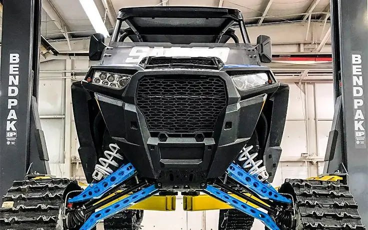BendPak XPR-18CL two-post lift holding a tracked off-road UTV; front view emphasizing extended height columns and heavy-duty arm configuration.