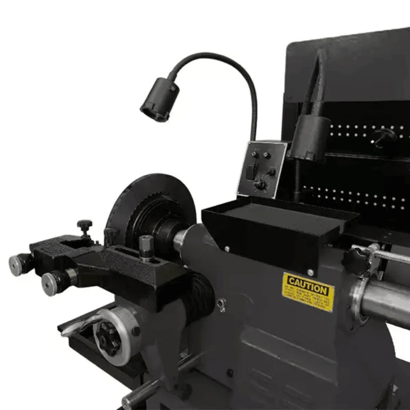 Katool RL-8500 brake lathe closeup showing cutting head assembly, precision feed controls, rotating disc mount, flexible task light, and caution label on housing.