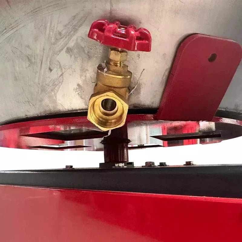 Katool RPM-80 Rim Polishing Machine close-up of brass drain valve with red handle located beneath stainless steel drum for fluid release