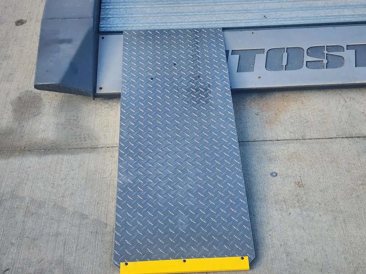 Autostacker 5174106 A6S EXT48 aluminum ramp closeup showing diamond plate surface texture and yellow edge for traction and visibility