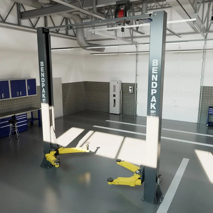 BendPak 10AP two-post lift installed in modern automotive garage with polished gray floor, overhead crossbar, and yellow swing arms positioned under ceiling lighting.