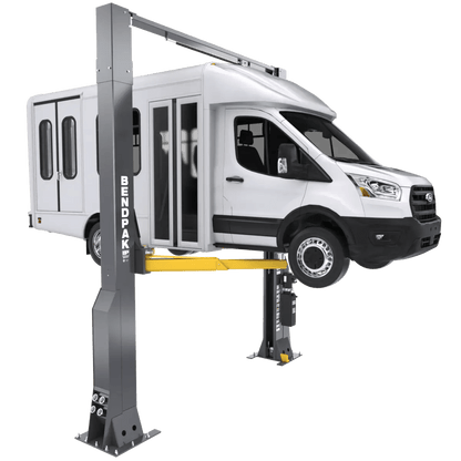 BendPak 16AP-192 two-post lift raising a white shuttle van, showing clearfloor design, gray columns, yellow telescoping arms, and overhead beam.

