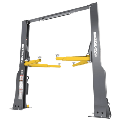 BendPak 16AP two-post lift shown in angled front-left view highlighting the gray steel columns, yellow lift arms, overhead crossbar, and control panel decal on the column.