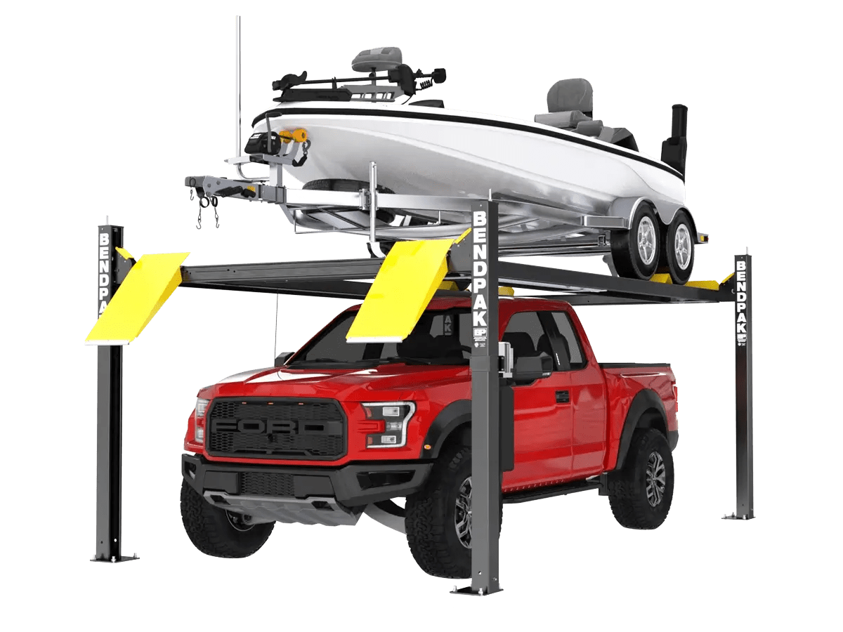 BendPak HD-75BXT extended-height four-post lift holding a red pickup truck on the lower platform and a white boat with trailer above, featuring tall steel columns, yellow ramps, and open design for vehicle and marine storage.