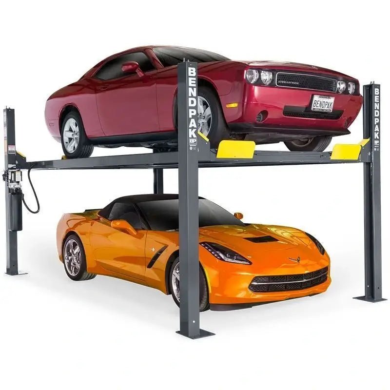 BendPak HD-9 four-post lift in studio hero view with two cars; runways, four columns with BENDPAK logos, wheel stops, and a front-left power unit.