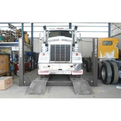 HDS-18E four post lift elevating a heavy duty tractor truck on long runways in an open bay, suitable for fleet maintenance operations