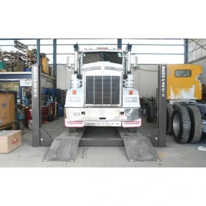HDS-18E four post lift elevating a heavy duty tractor truck on long runways in an open bay, suitable for fleet maintenance operations