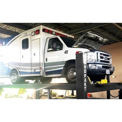 BendPak HDS-14 four-post lift supporting a Ford ambulance vehicle during maintenance, showing high-capacity design and platform strength.