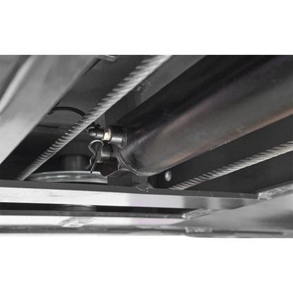 BendPak HDS-14 four-post lift underside showing hydraulic cylinder assembly with safety pin and routed steel cables.