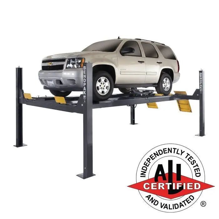 BendPak HDS-14LSXE extended four-post alignment lift in a professional garage setup, showing long wheelbase platform and dual approach ramps.