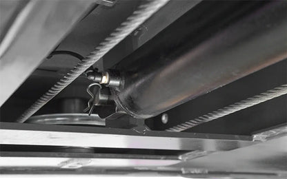 BendPak HDS-14X four-post lift closeup of hydraulic cylinder and steel lift cables, underside view showing locking pin mechanism.