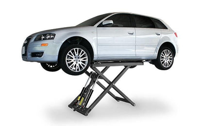 BendPak MD-6XP 6,000-lb capacity mid-rise lift raising a white sedan; side angle shows scissor mechanism and lift pad placement.