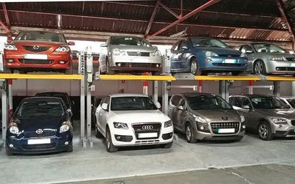 BendPak PL-6000DC two-post parking lifts used in private garage; cars stored on upper and lower levels within compact bays.
