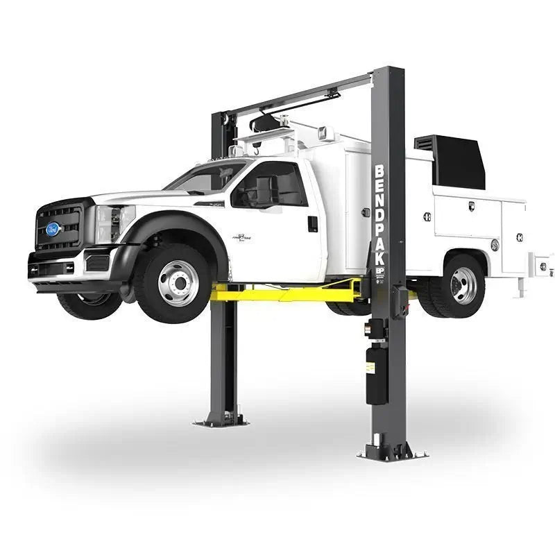 BendPak XPR-12CL-LTA two-post lift raising a Ford service truck; hero angle highlights tall columns, clearfloor crossbar, and heavy-duty lifting arms.