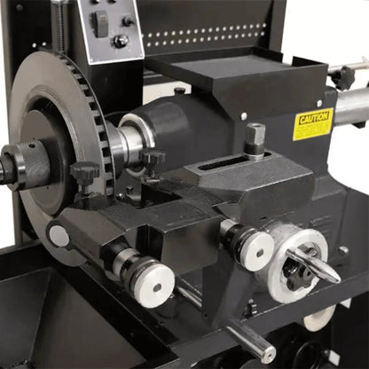 Katool RL-8500 brake lathe closeup showing twin cutting head assembly with adjustment knobs, rotor mount, tool holder, and visible caution label on the housing.